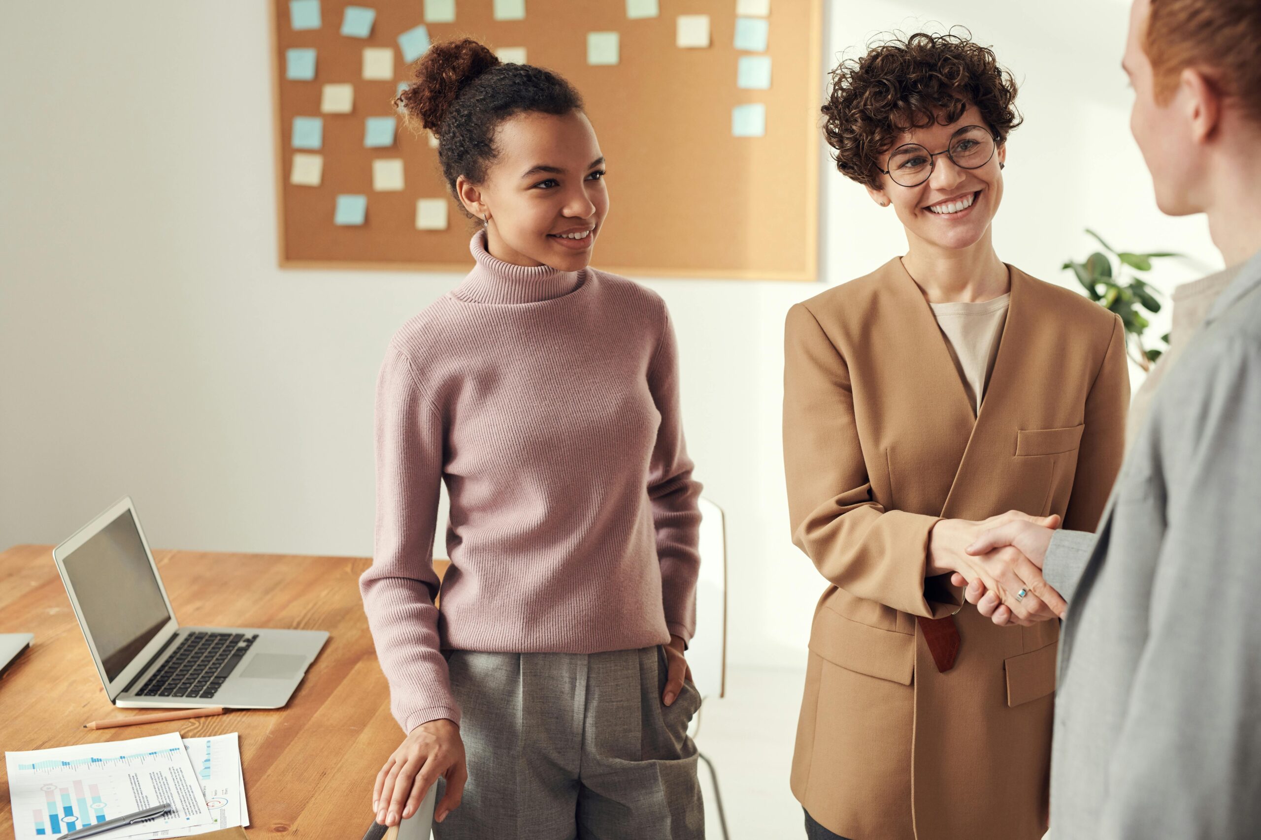Handshake between colleagues in a business setting, symbolizing a beginning of a career in sales.